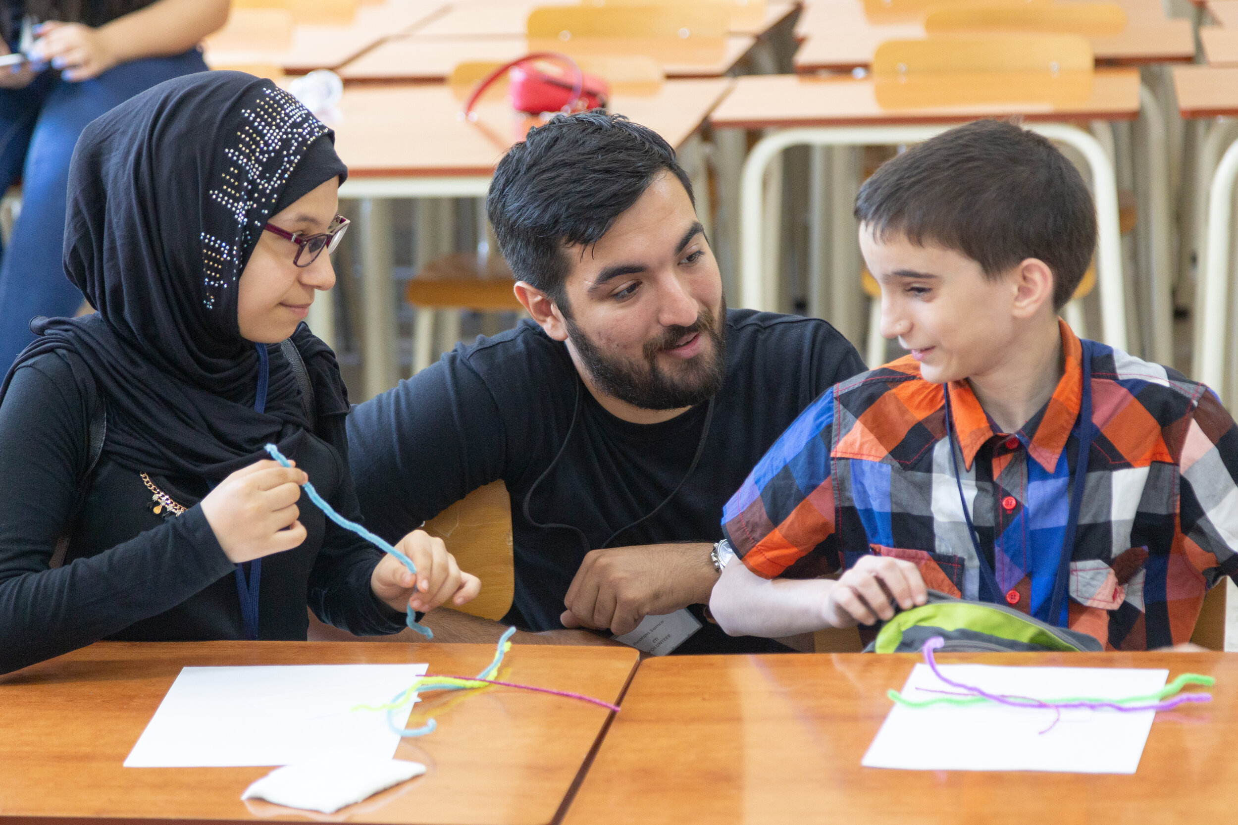 A volunteer works with a young student completing an art project