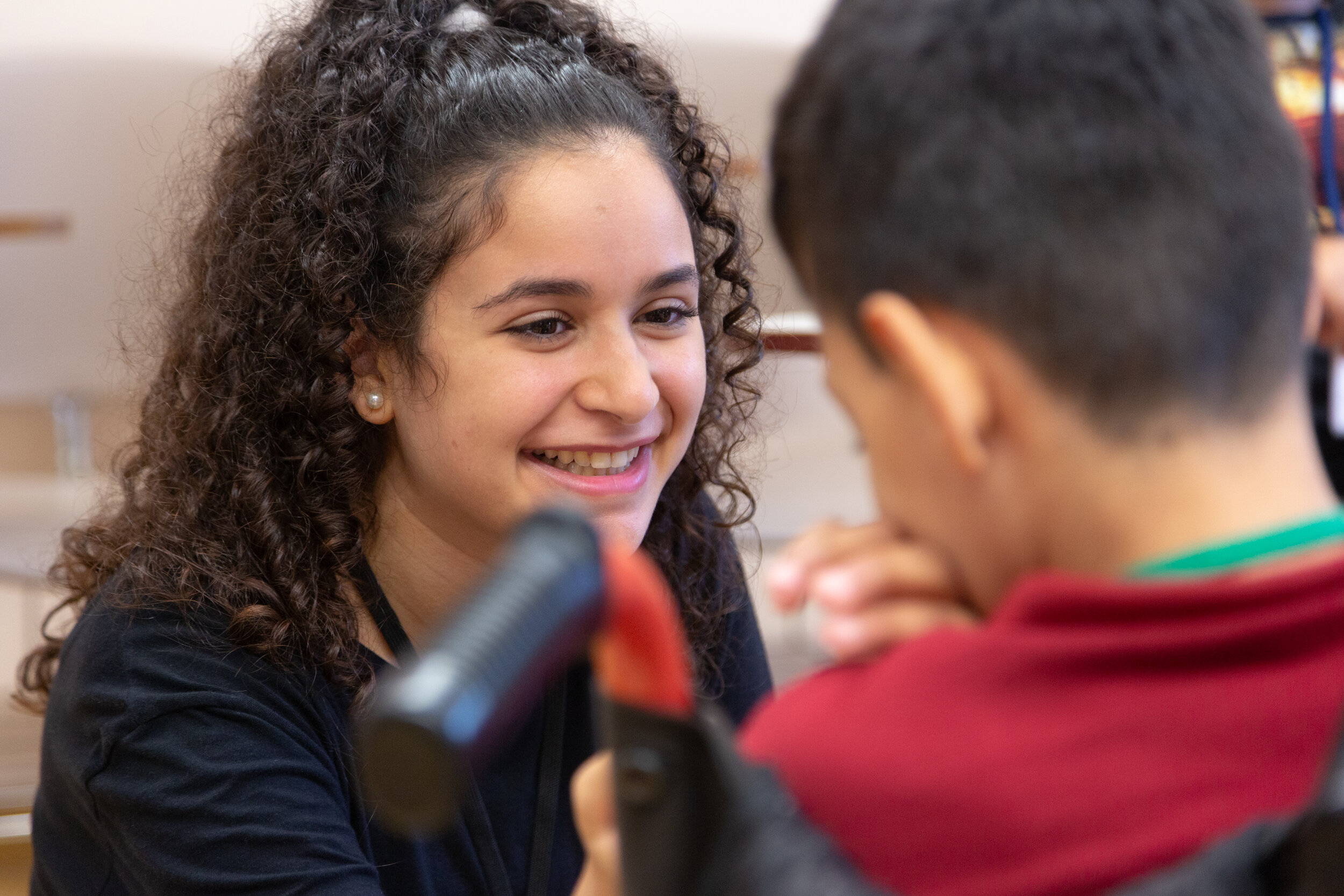 Two students smile as they talk together