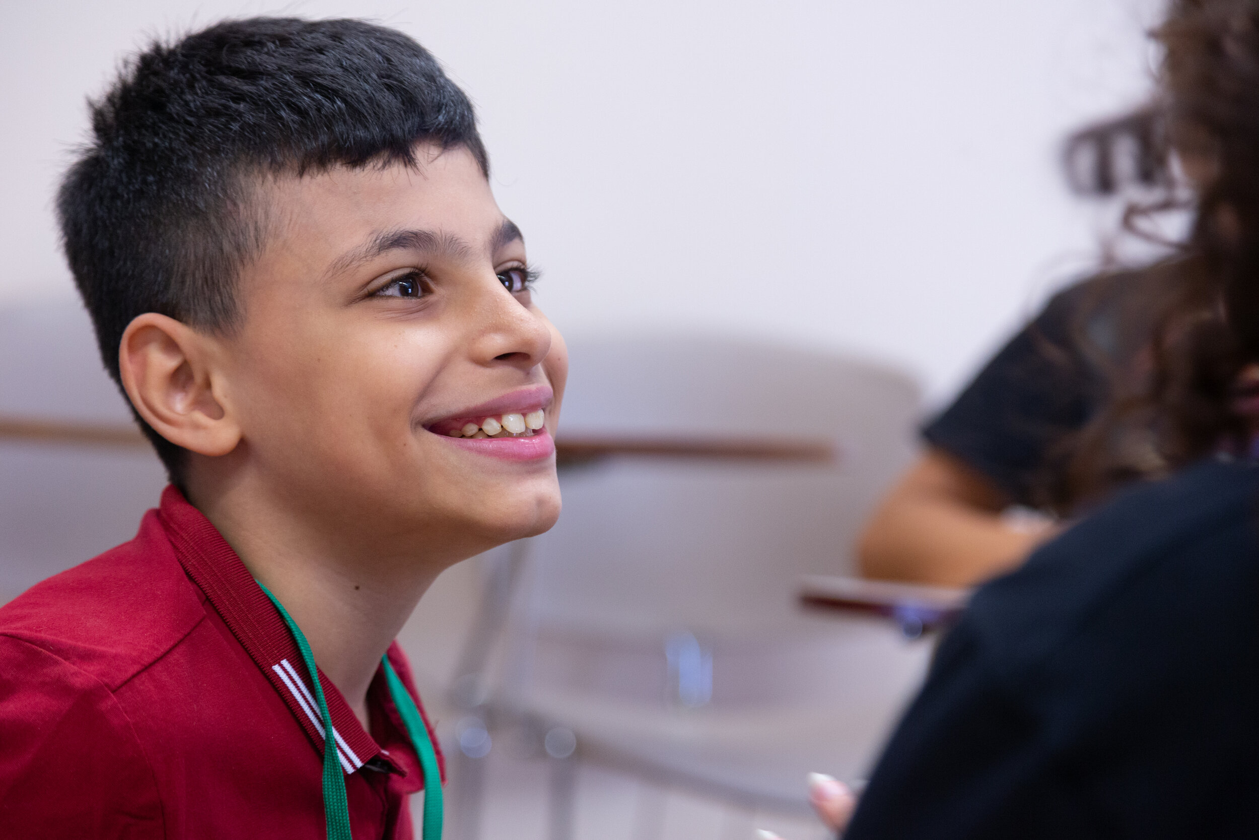 A young student smiles as he gazes to the crowd