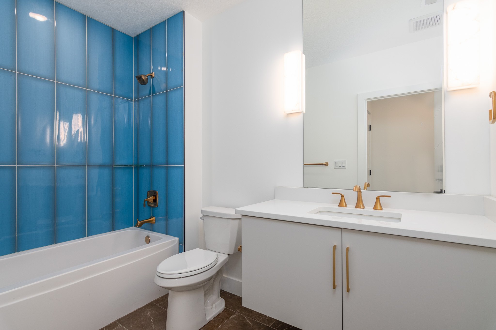 guest-bathroom-large-blue-tiles-white-vanity-gold-hardware.jpg