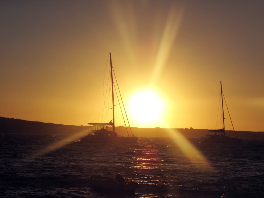 Santorini_amouldi bay_boats passing at sunset.jpg