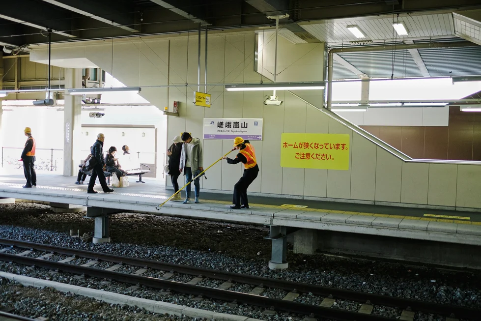 Someone getting their phone back after dropping it on the train tracks