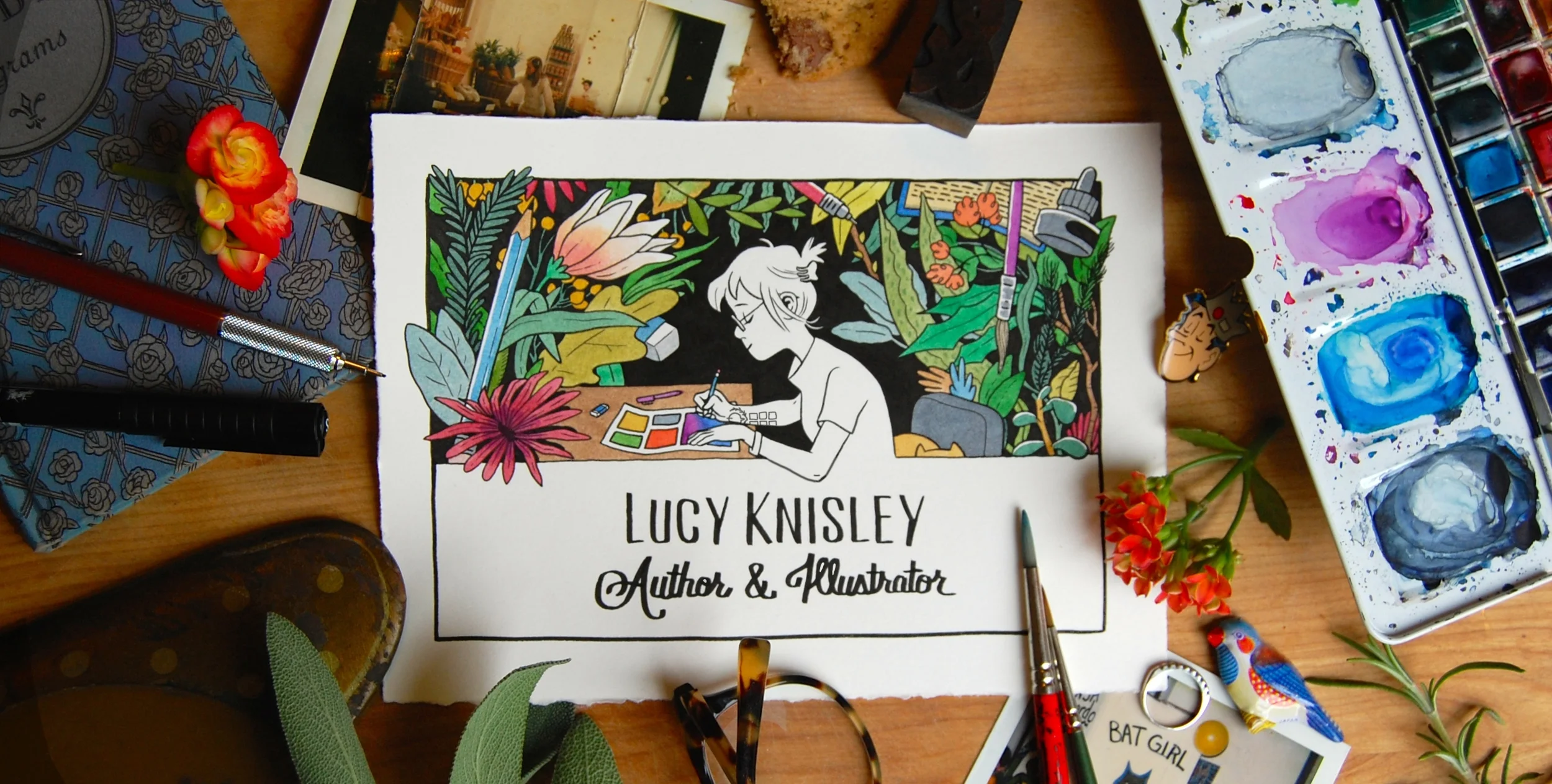A colorful illustration of Lucy Knisley, an author and illustrator, drawing at a desk surrounded by lush, vibrant plants, with her name and title written below. The workspace includes watercolor paints, brushes, flowers, and various art supplies.