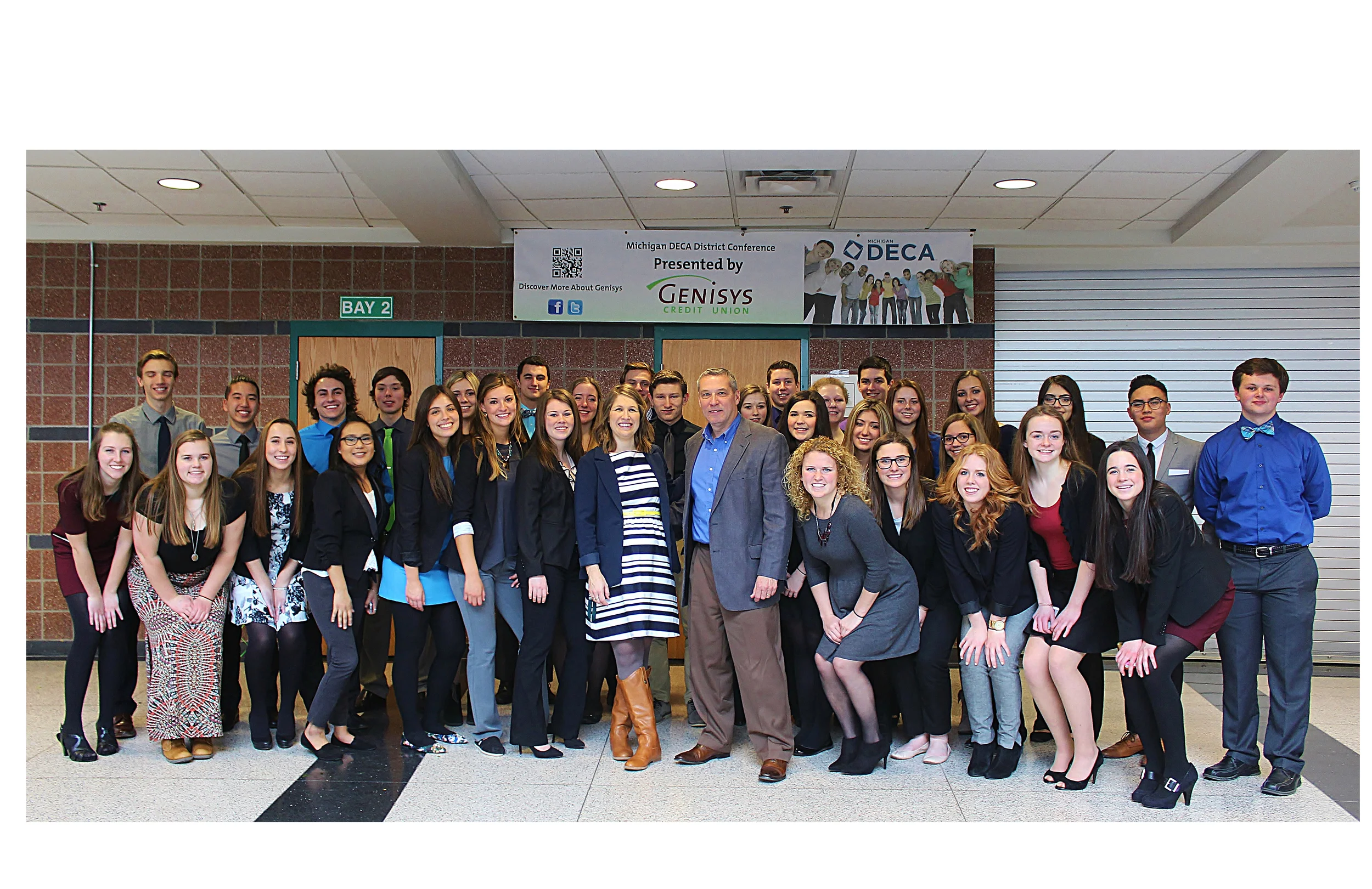 Above: Custom Threads & Sports, a long time local supplier of Lake Orion-branded apparel to school athletic programs and the community, recently provided a grant to the Lake Orion High School DECA team of students interested in sales and marketing careers. According to Custom Threads' President Mark McCord, the donation was made in recognition of the successful partnership between his business and the school district to provide goods for the high school's student run store and Lake Orion's web based spirit wear outlet. Pictured, DECA Advisor Julia Dalrymple and Mark McCord, along with the students who competed in the recent DECA regional competition at Lake Orion High School. Photo Credit: Joe St. Henry. 
