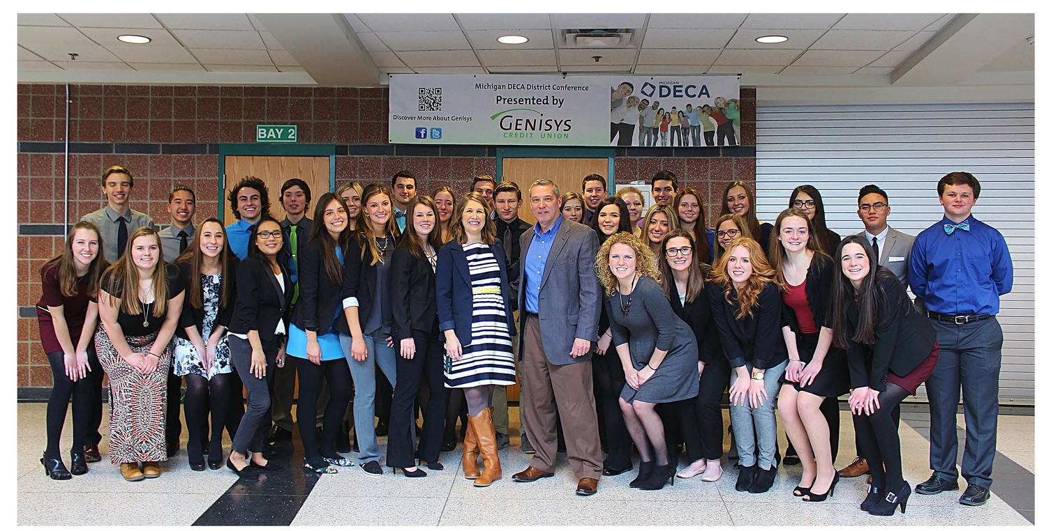 Above: Custom Threads & Sports, a long time local supplier of Lake Orion-branded apparel to school athletic programs and the community, recently provided a grant to the Lake Orion High School DECA team of students interested in sales and marketing careers. According to Custom Threads' President Mark McCord, the donation was made in recognition of the successful partnership between his business and the school district to provide goods for the high school's student run store and Lake Orion's web based spirit wear outlet. Pictured, DECA Advisor Julia Dalrymple and Mark McCord, along with the students who competed in the recent DECA regional competition at Lake Orion High School. Photo Credit: Joe St. Henry. 