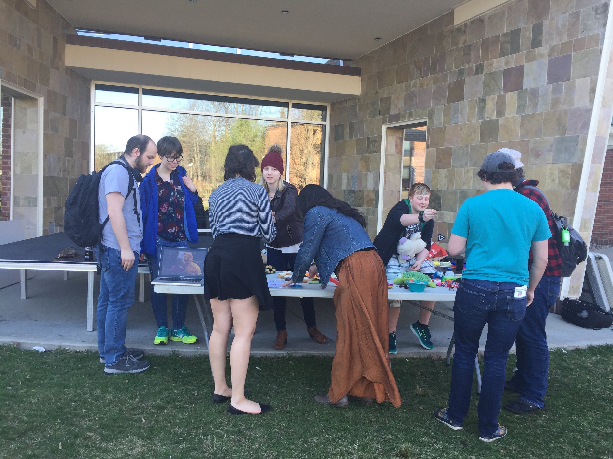 Image description: Students at Skidmore College gathered around a table of stim toys and autism acceptance materials.