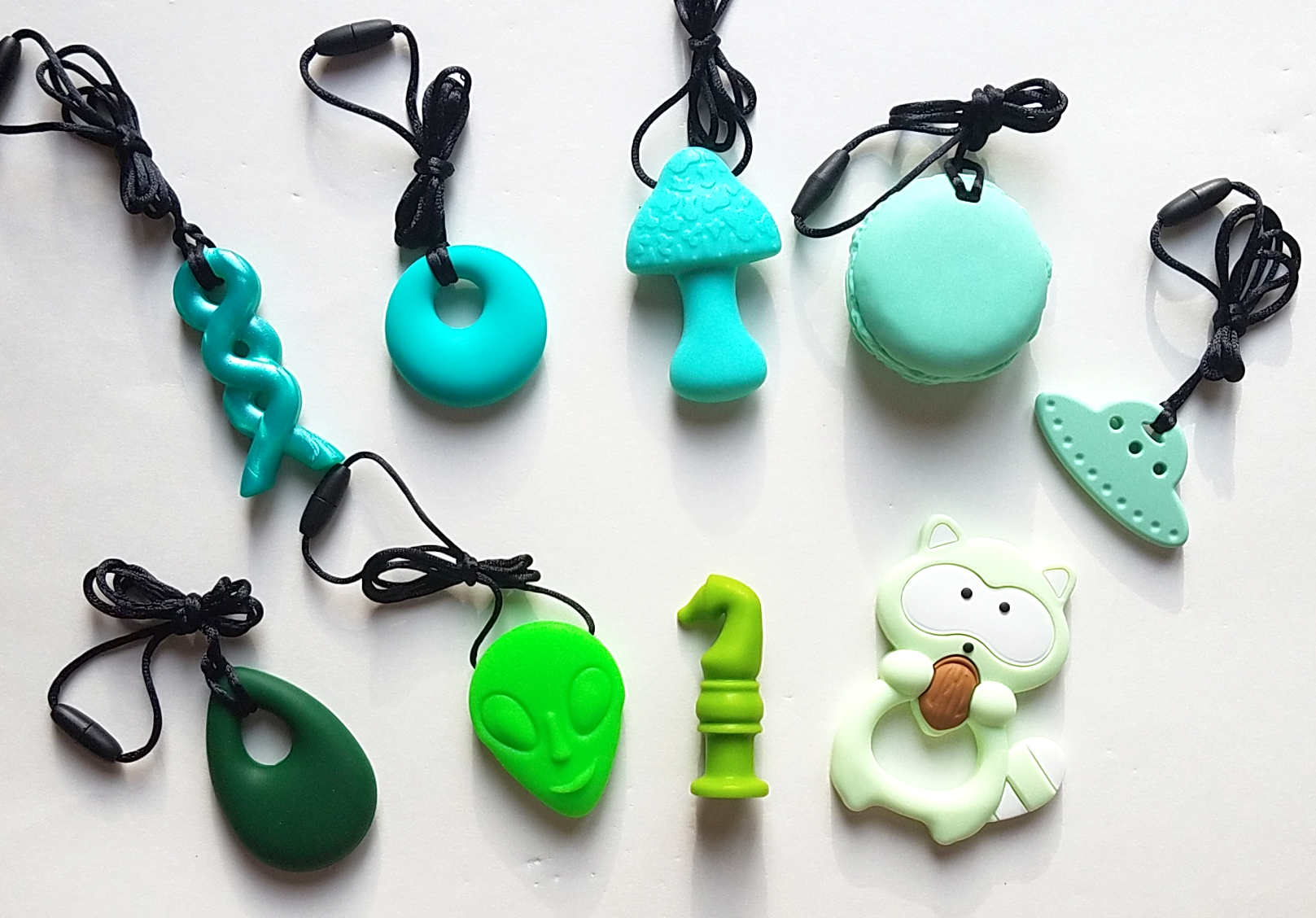 Clockwise from top left: Azure braid, turquoise annular, mint mushroom, green macaron, mint UFO, green raccoon, lime green chew knight, neon green alien, emerald droplet.