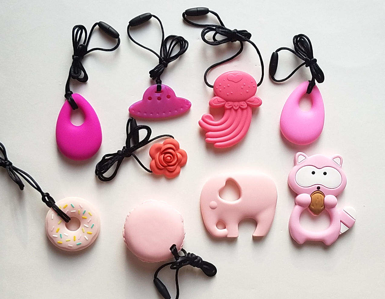 Clockwise from top left: Fuschia droplet, ruby UFO, pink jellyfish, pink droplet, pink raccoon, pink elephant, pink macaron, pink donut, coral blossom.
