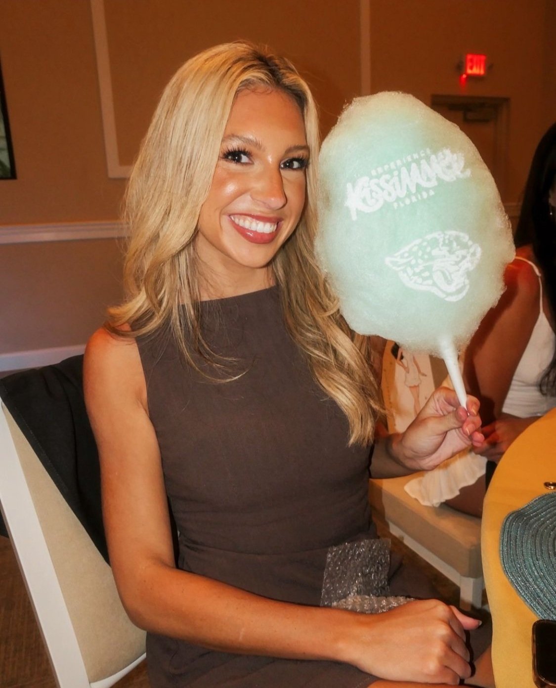 a woman holding a cotton candy cone with a logo design