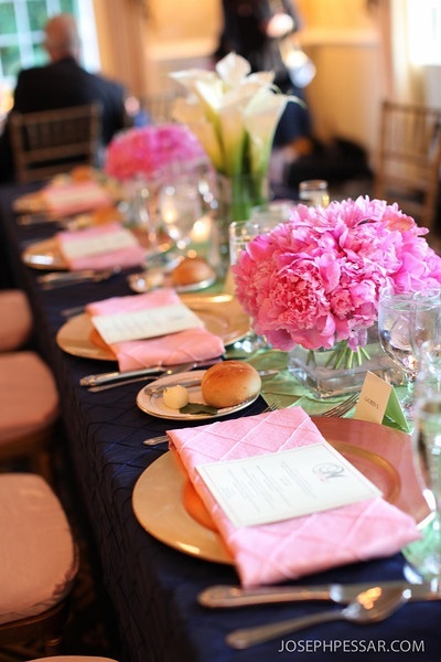 There was a modified head table for the bridal party, we did a collection of vases in round balls of peonies, orchids, and callas in varying square containers with votives scattered in between to create a beautiful lush table scape, which looked simpley gorgeous with the colorful pintuck linens and gold accented chargers and chivari chairs.