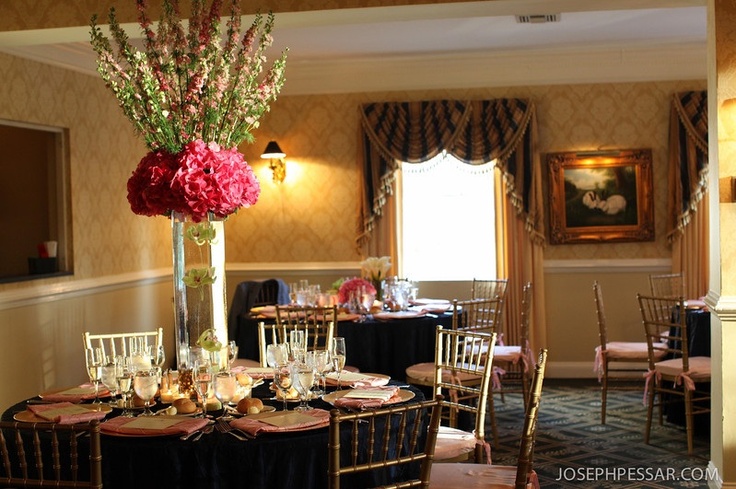 Tall topiary style arrangements of pink hydrangea and larkspur over a tall square glass vase holding suspended cymbidium orchids created a modern, structural and elegant piece.