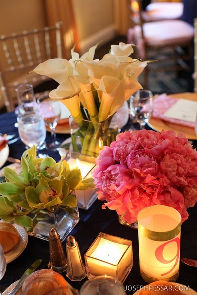 Low monoflora bouquets of callas, peonies and cymbidiums with large square candles created a simple elegance to the table.