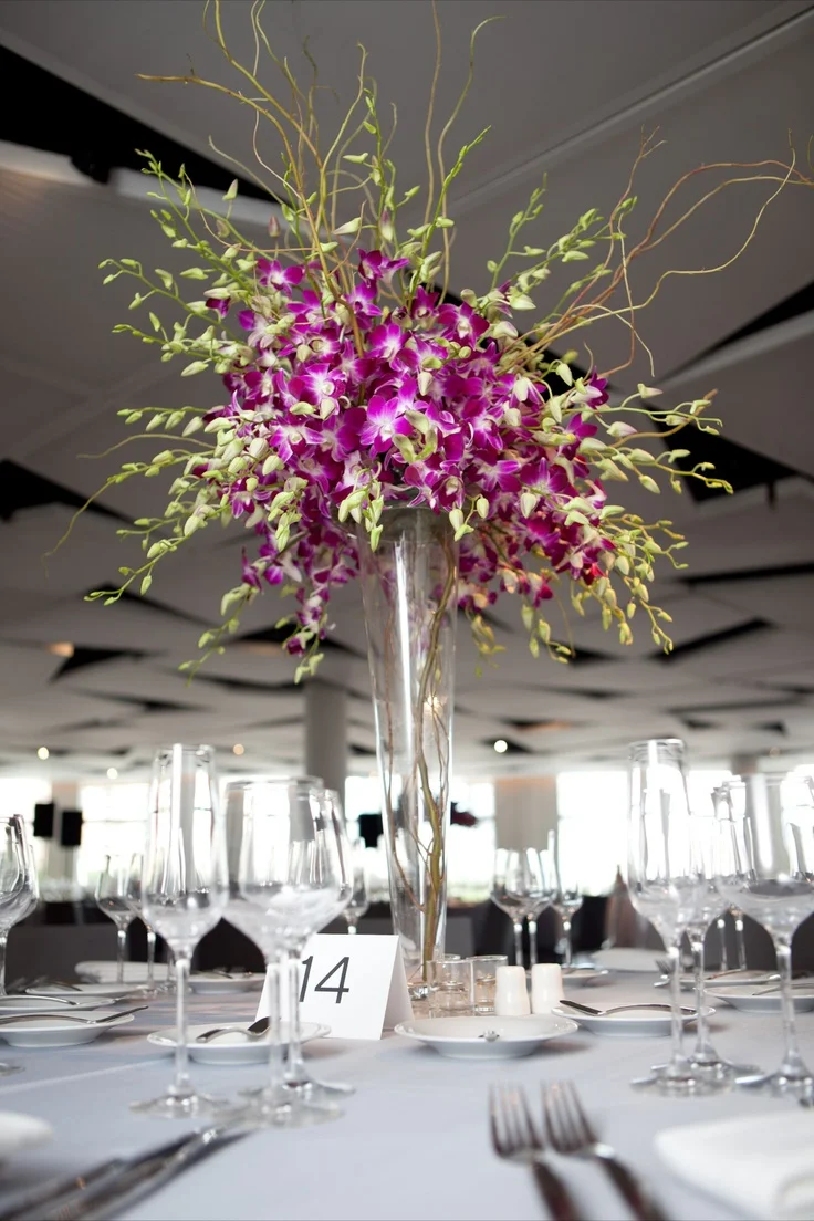 For the second style of centerpiece we did a simple spray of dendrobian orchids atop a fluted vase with striped curly willow branches woven in between the blossoms.