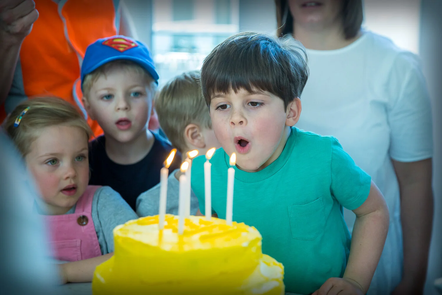 Young boy blowing out candles on birthday cake