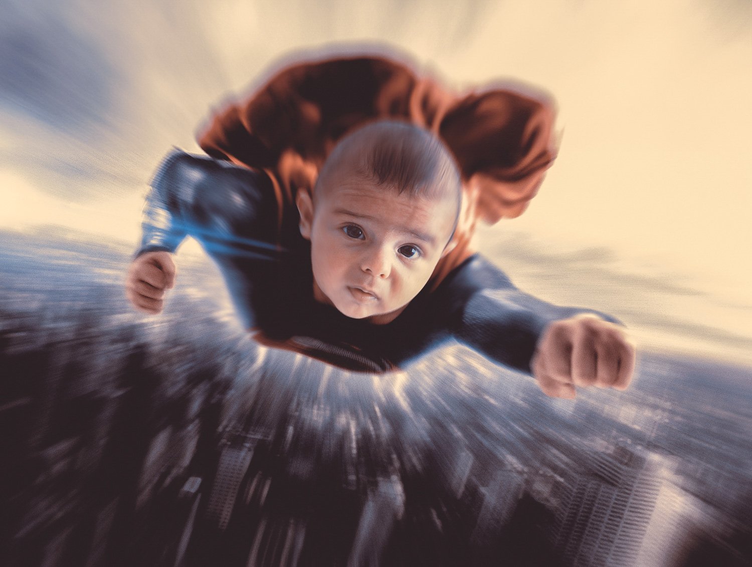 A baby boy dressed as Superman flying high above a city