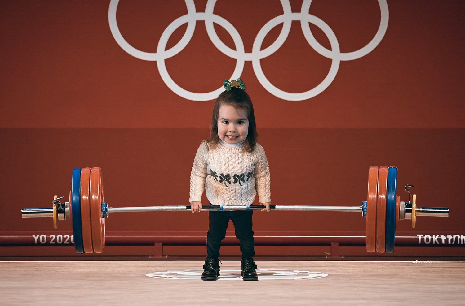 A little girl lifting a barbell in a weightlifting competition 