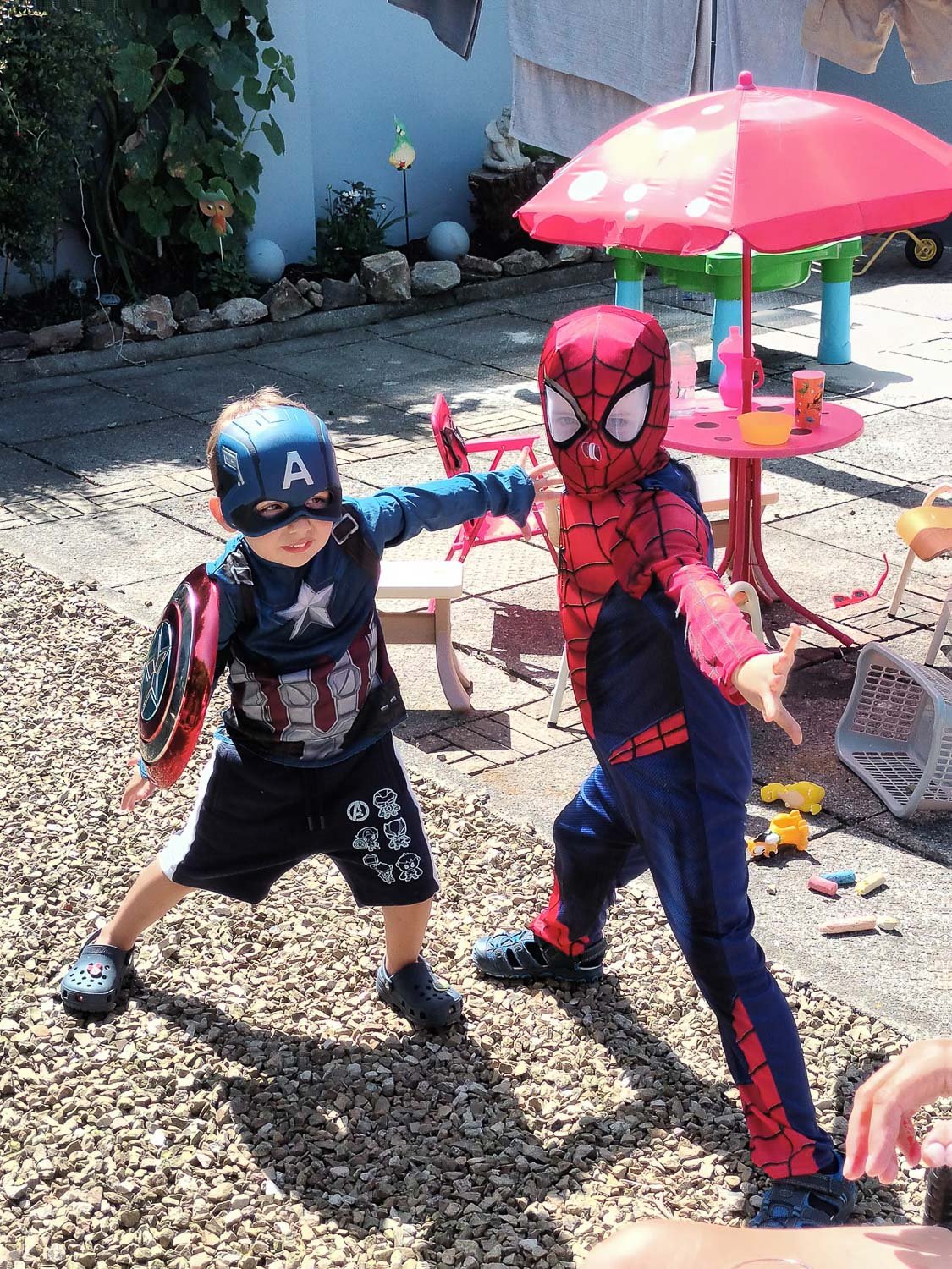 Two boys dressed as super heros posing outside