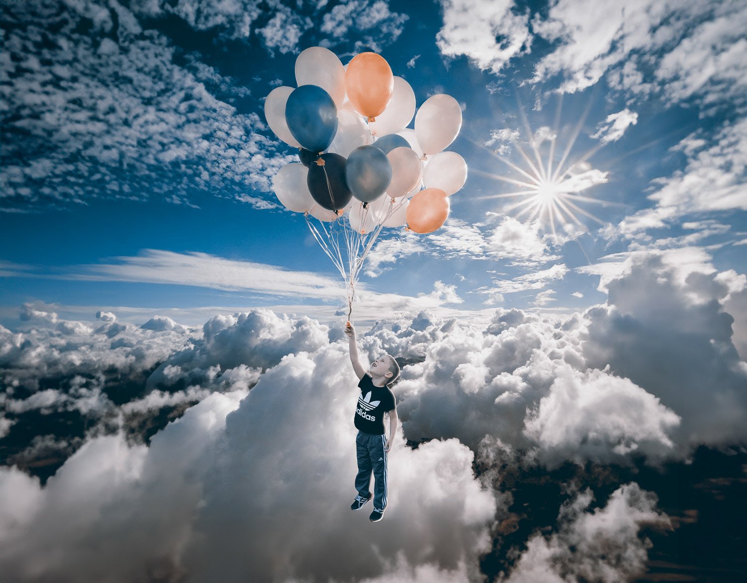 A young boy holding balloons floating high above the clouds 
