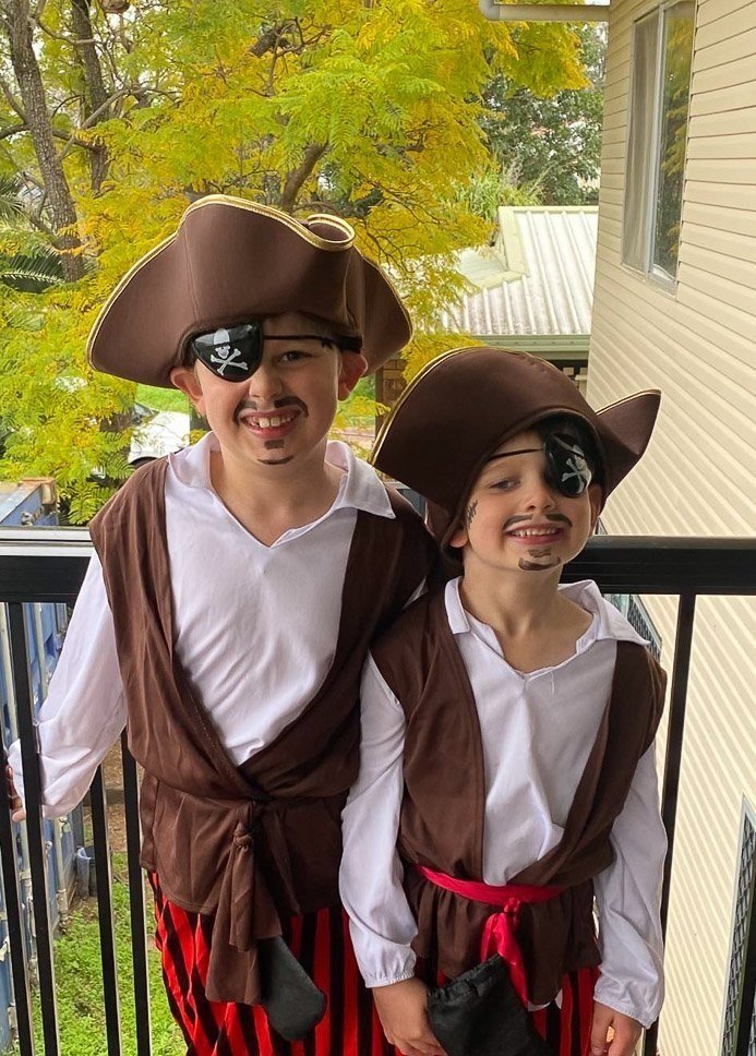 Two boys standing on a balcony dressed as pirates