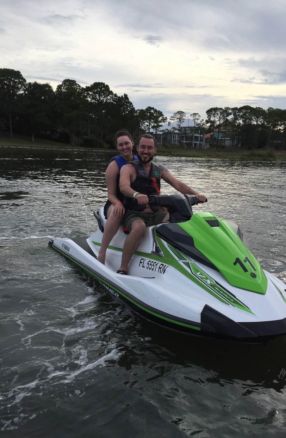 A couple sitting on a jet ski on the water