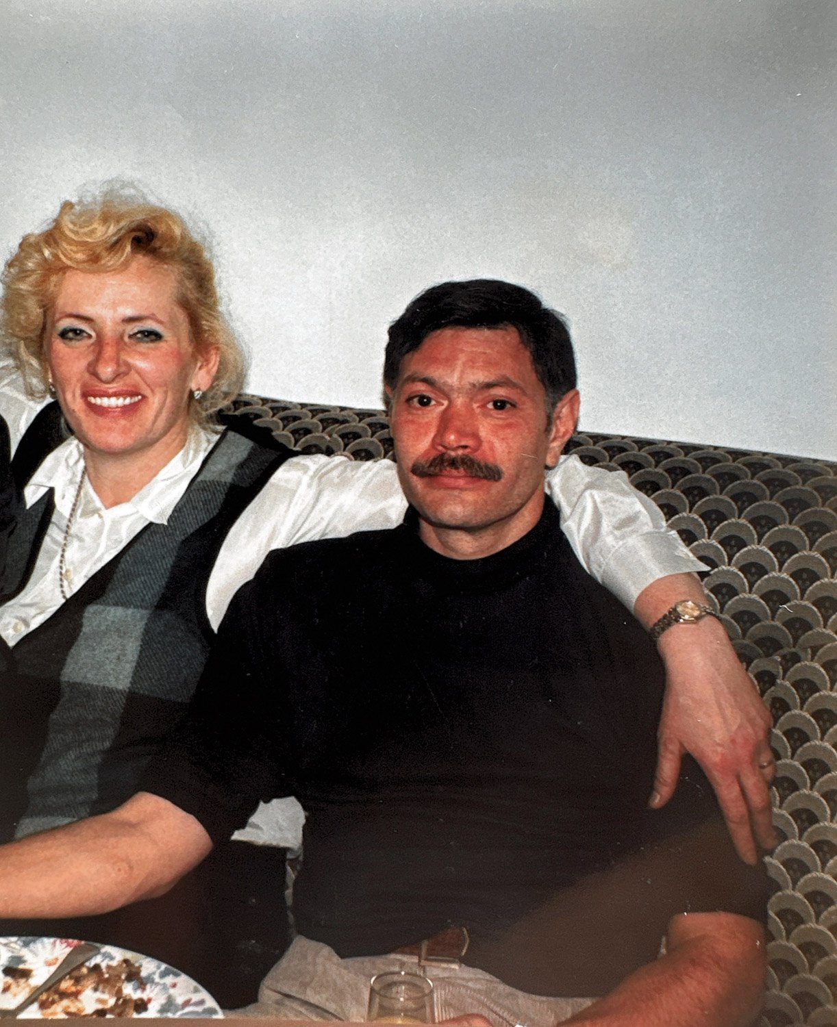 A man and woman sitting inside on a couch 