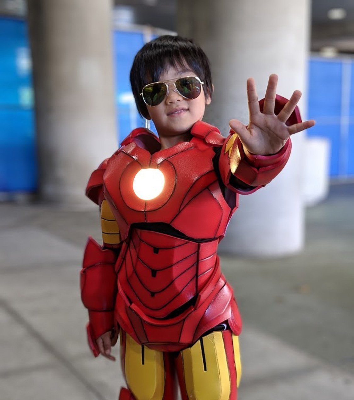 Young boy with sunglasses in Iron Man costume