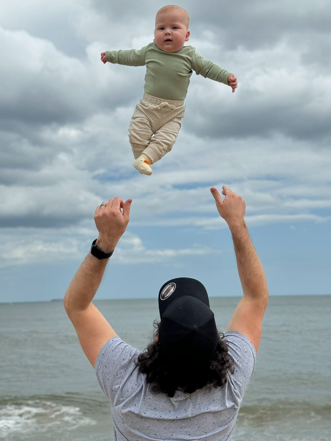 A man tossing a baby boy high above his head