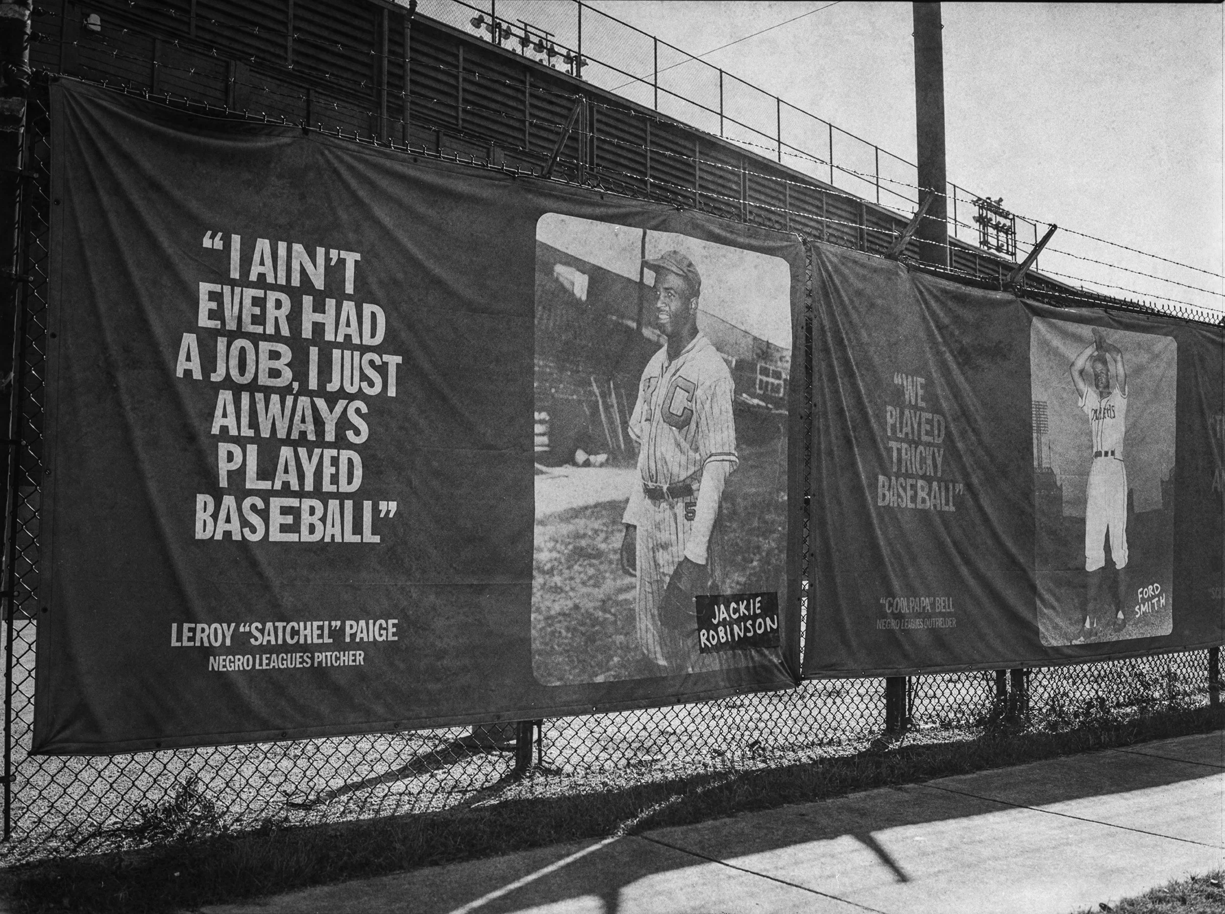 Negro League Baseball flags of baseball legends outside at Rickwood Field - Oldest baseball stadium in America located in Birmingham, Alabama. B&W Kodak Tri X Film Photography by Ricky Davis of TRD Photography
