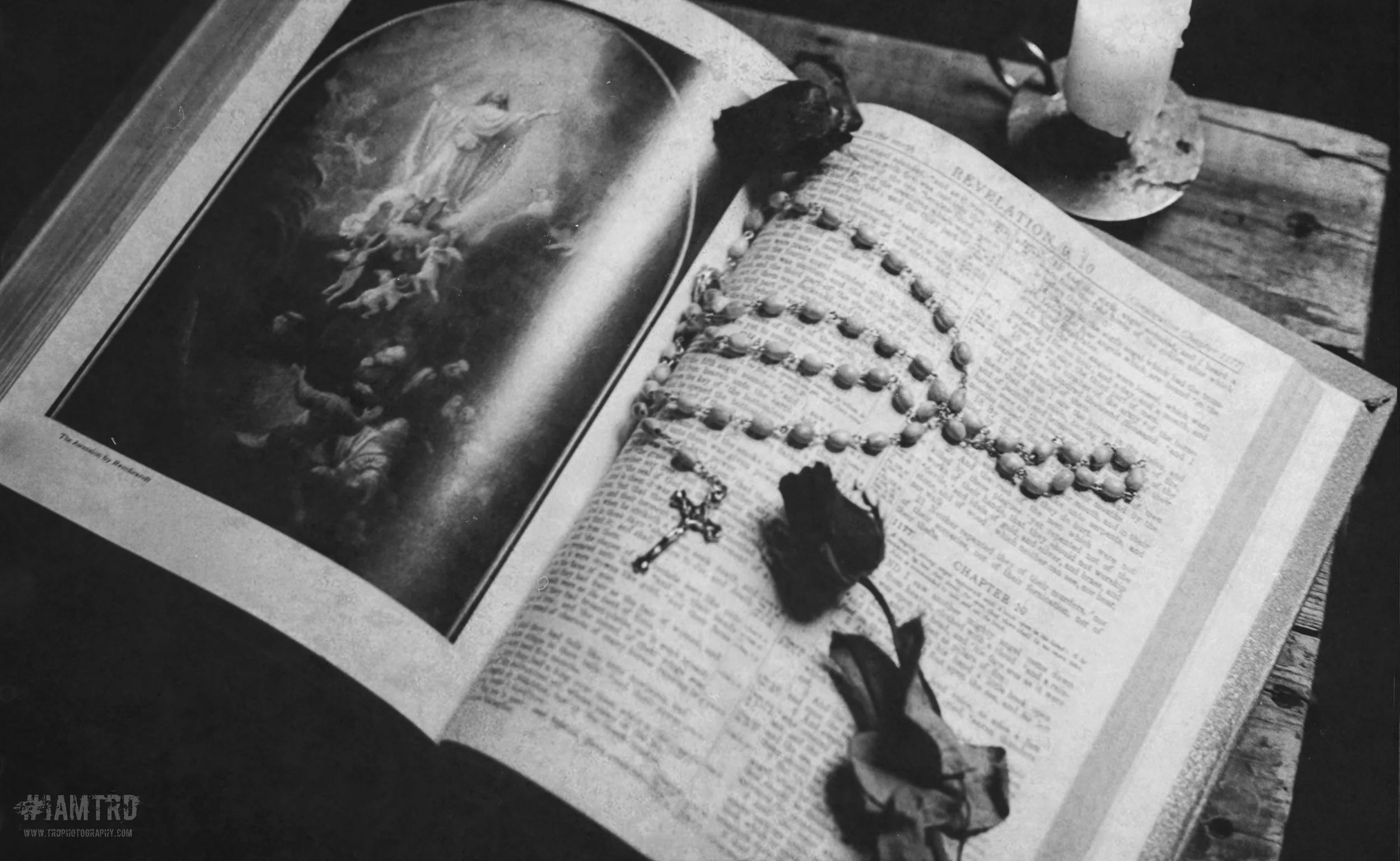 Open Bible with beads and dried flowers on pages, with image of Jesus appearing to his disciples on the left page.