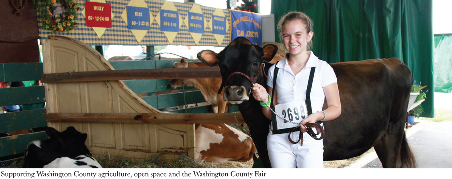 Girl standing next to her cow smiling at the Washington County Fair