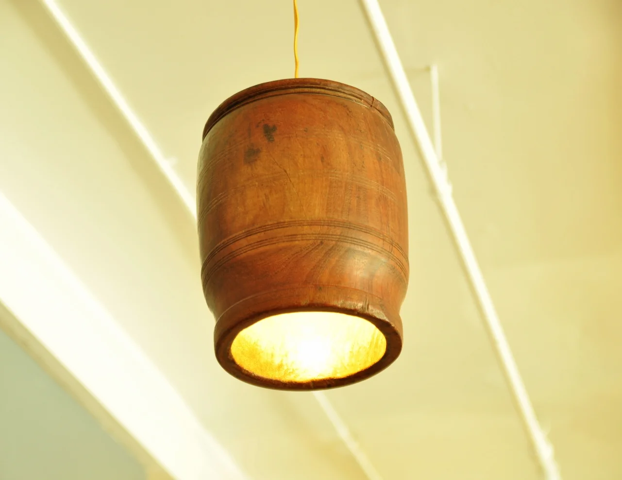 An antique indian vessel repurposed as a pendant lamp