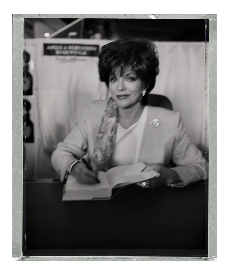 (Here’s the pictures of Joan Collins. I was on my way to a job and walked past a crowd gathered in front of a shopping mall. When I heard over the tannoy ‘ladies and gentlemen put your hands together for Joan Collins’ I muscled my way to the front. She liked my camera:-).