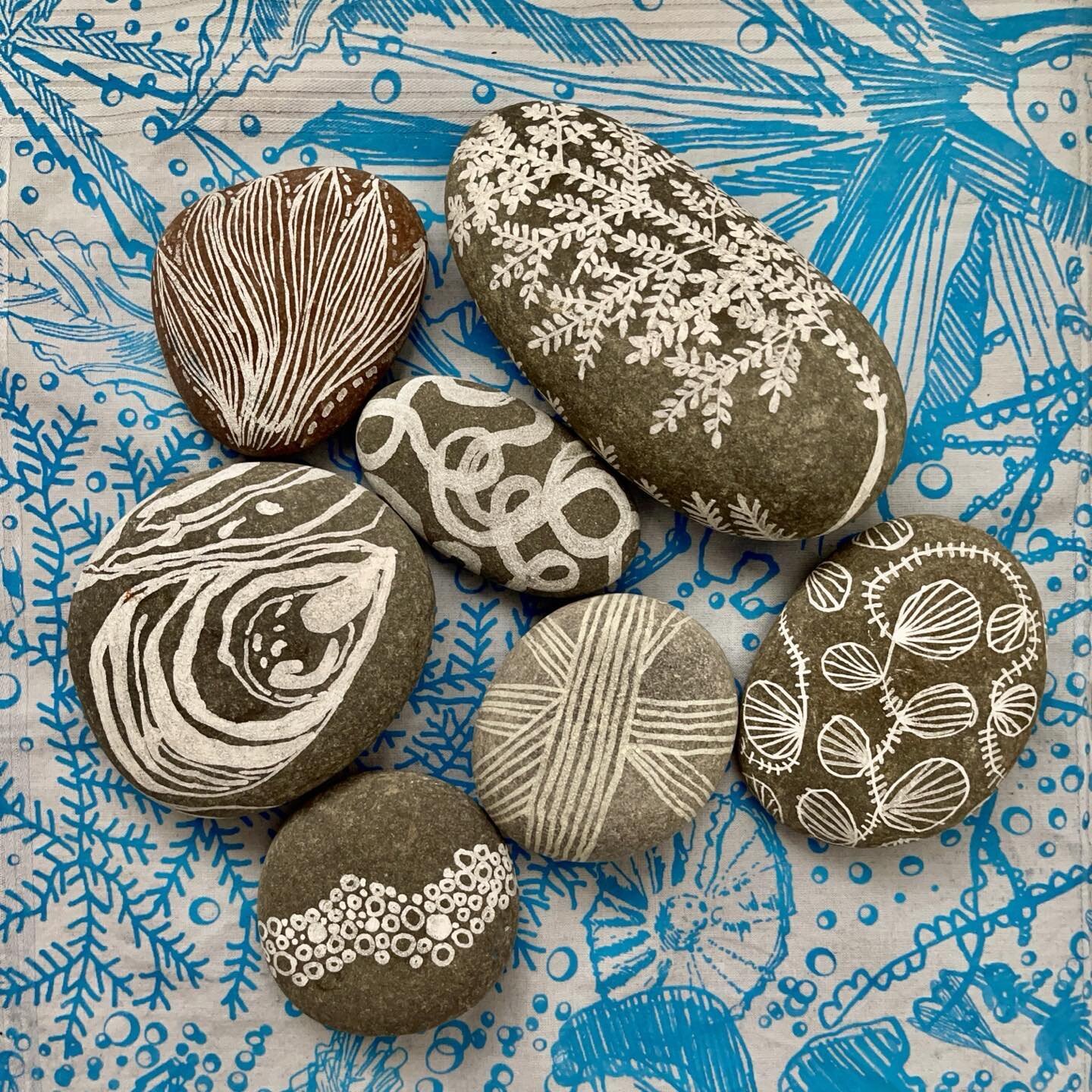 Here are some pebbles that I painted with items that I found beach combing. They are sitting a top one of my man sized hankies which are screen printed by me with my seaweed designs.