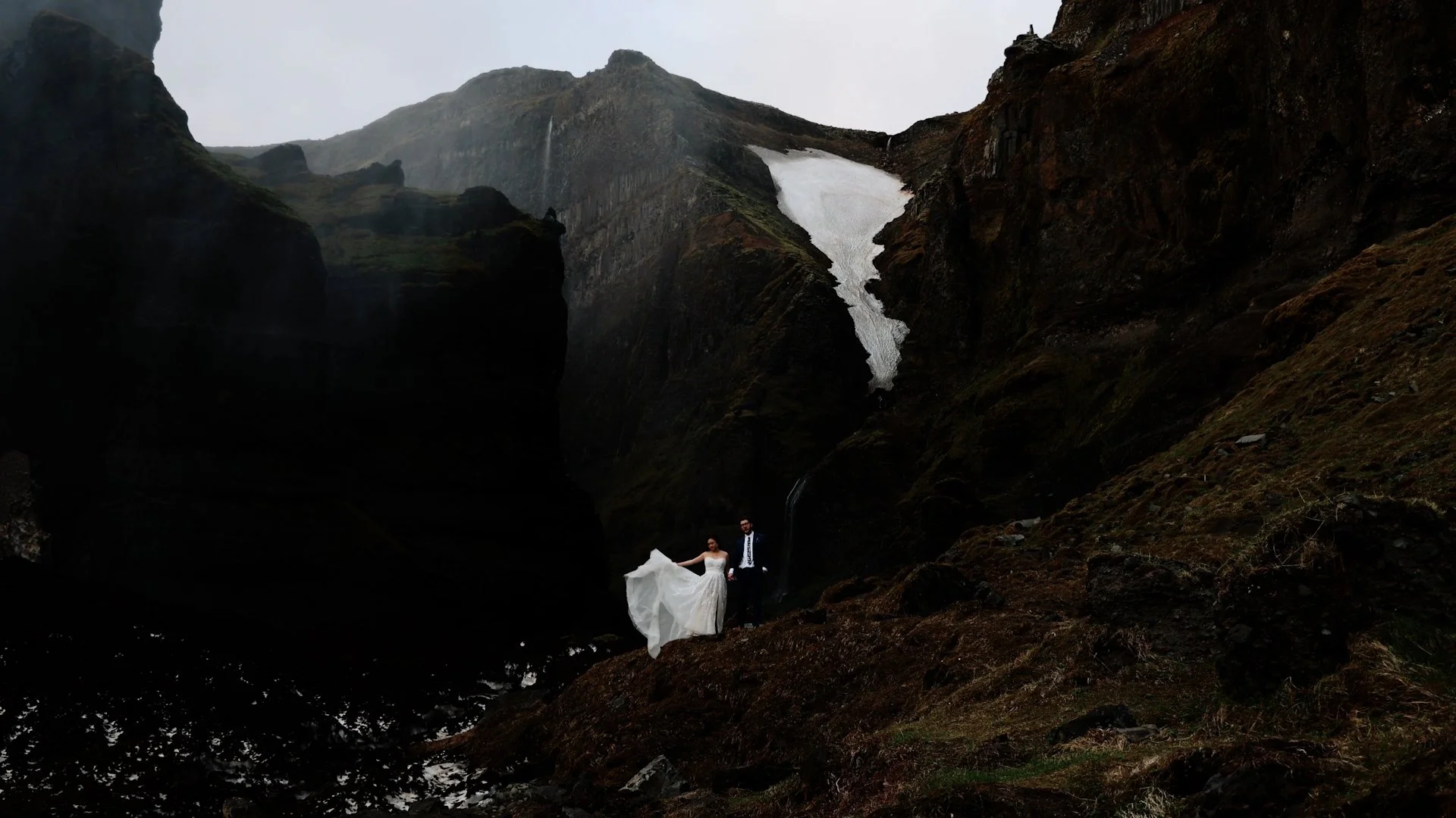 iceland elopement couple stand on mossy hill.jpg