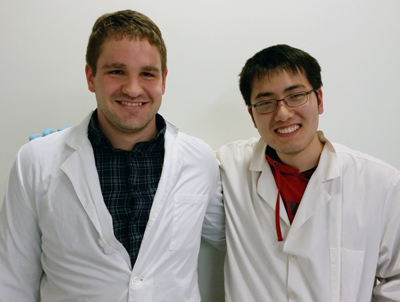 Picture of Shane Falcinelli and Iowis Zhu in lab coats.