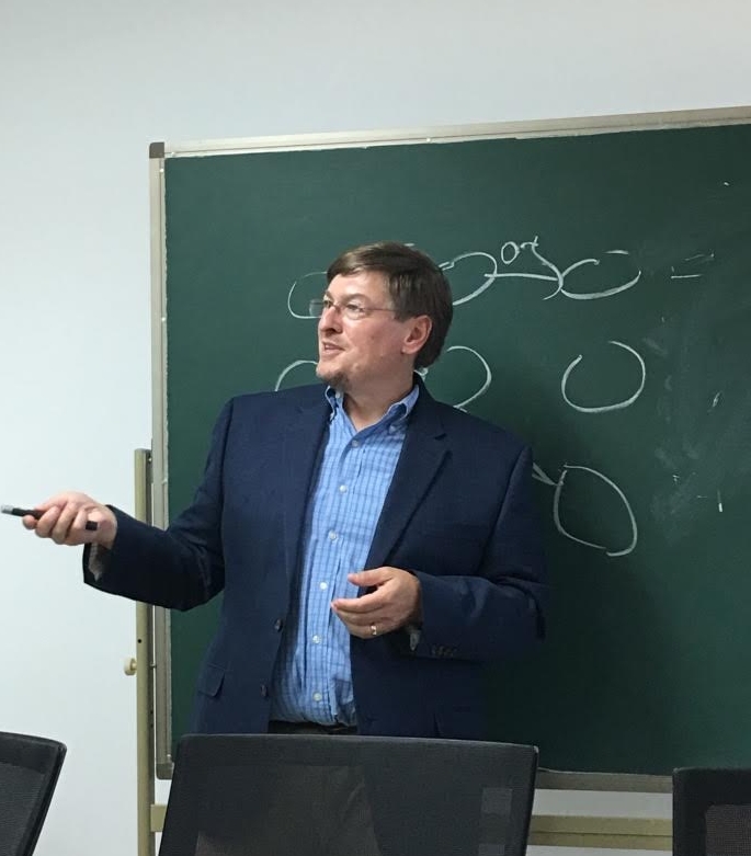 Picture of Dr. Jonathan Simon in front of a blackboard.