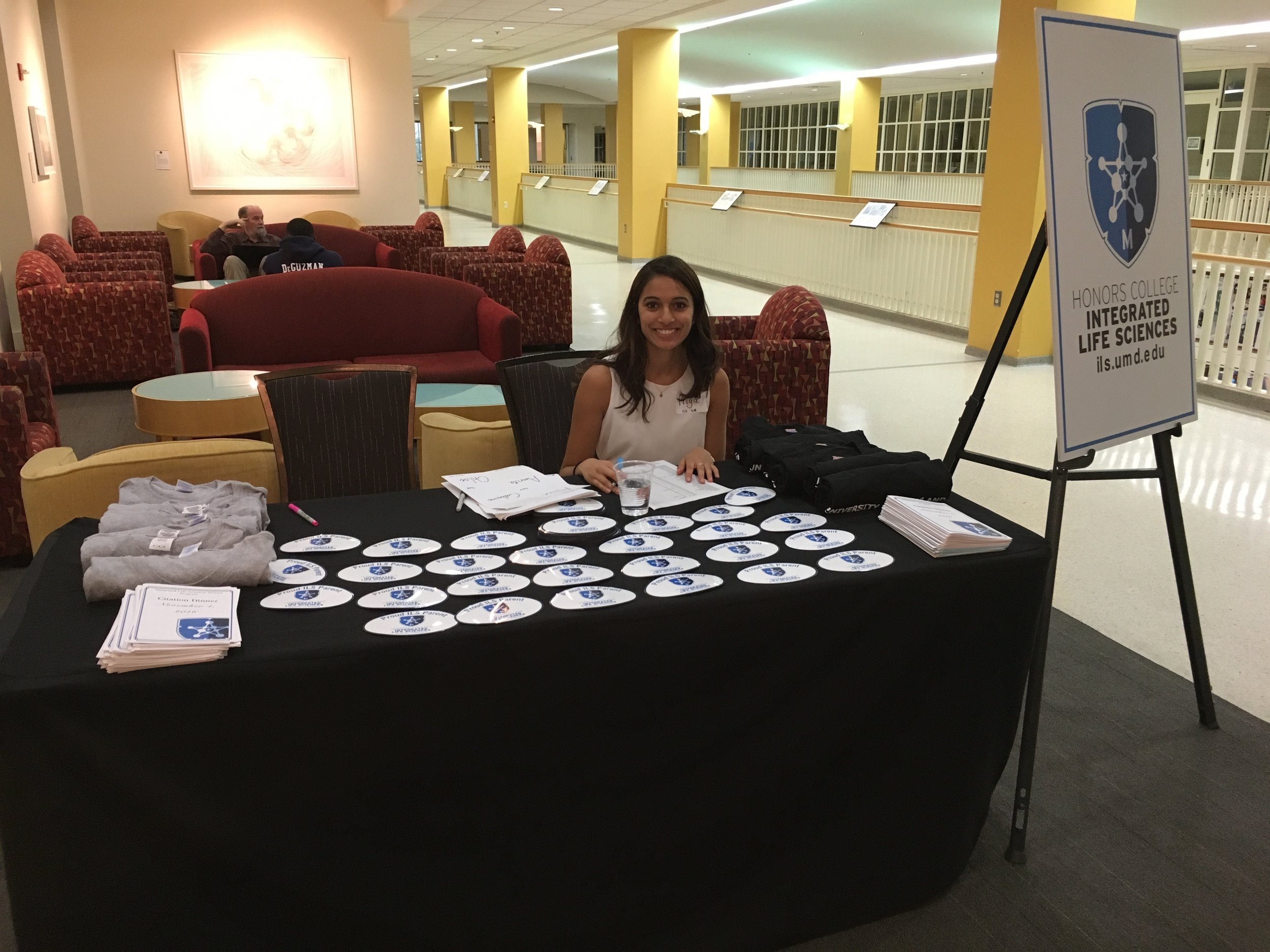 Picture of ILS welcome table with ILS stickers and programs.
