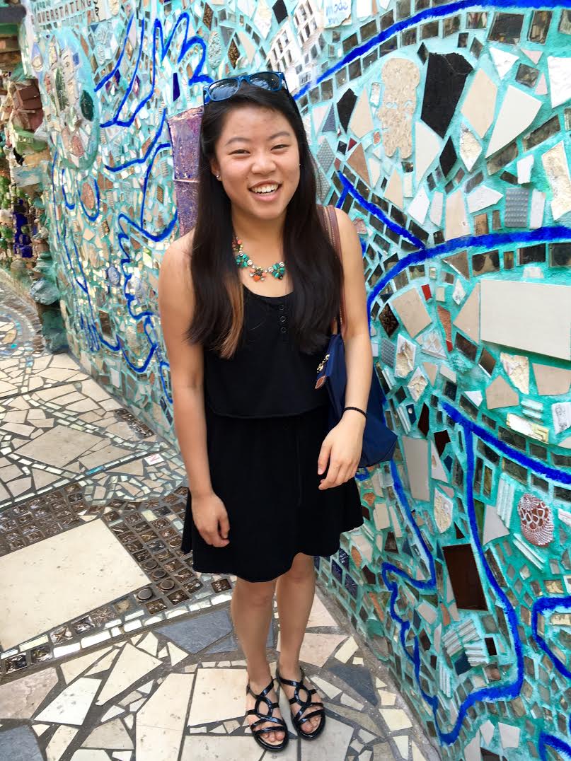 Picture of Nicole Moy in front of a mosaic.
