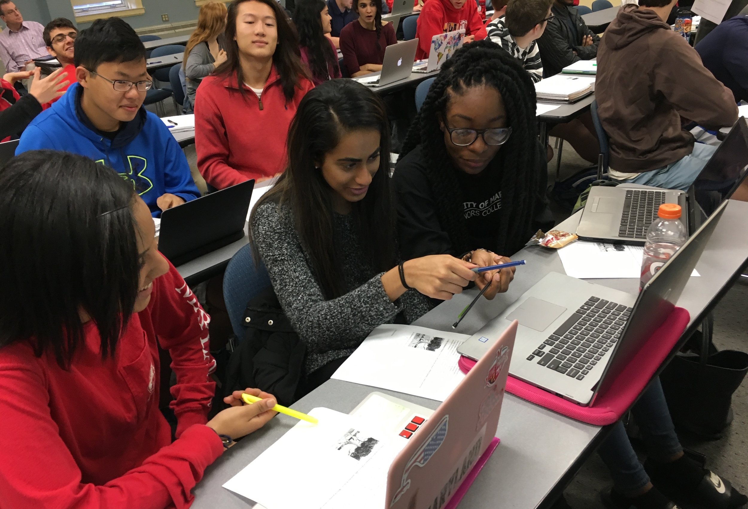 ILS students with laptops working together on a project