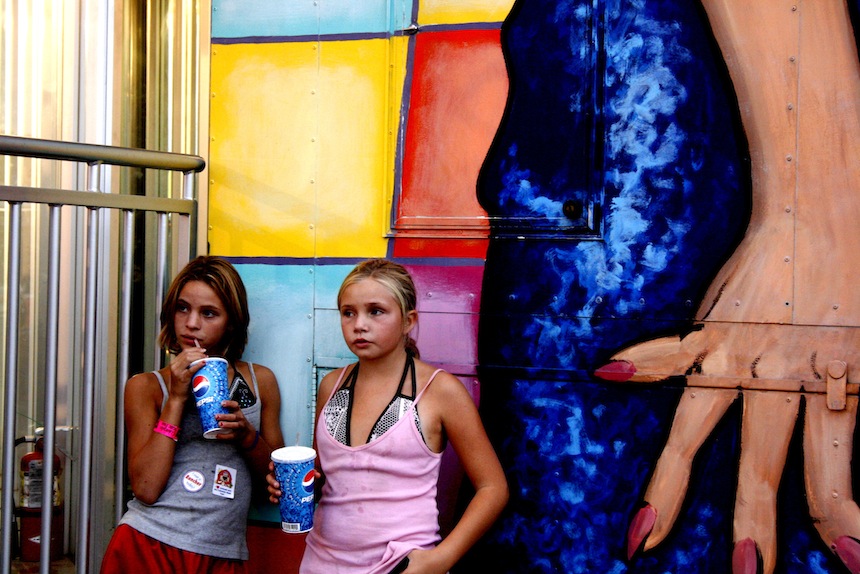 Two pre-teen girls take a break between thrill rides at Colorado State Fair in Pueblo, Colo. 