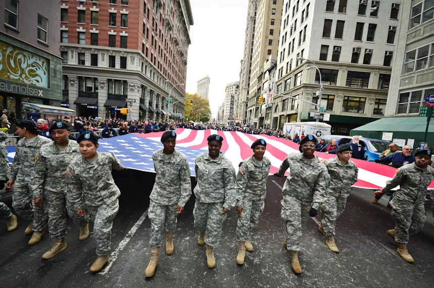 A group of female soldiers marches with the Star Spangled flag at the New York City Veteran's Day Parade Nov., 11, 2013. 