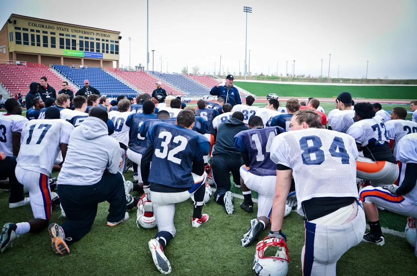 John Wristen, 2011 National Coach of the Year by American Football Monthly magazine, speaks to the team after practice. Under his direction, the CSU-Pueblo Thunder Wolves rose from a startup in 2008 to a national championship contender in RCAA Division II playoffs in just a few years.