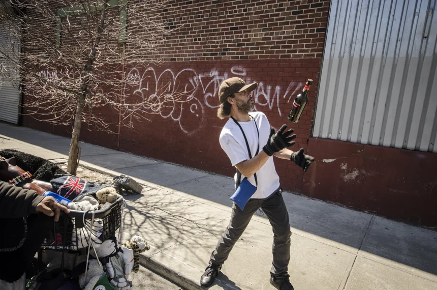 José tosses a bottle he found on the street in the air.