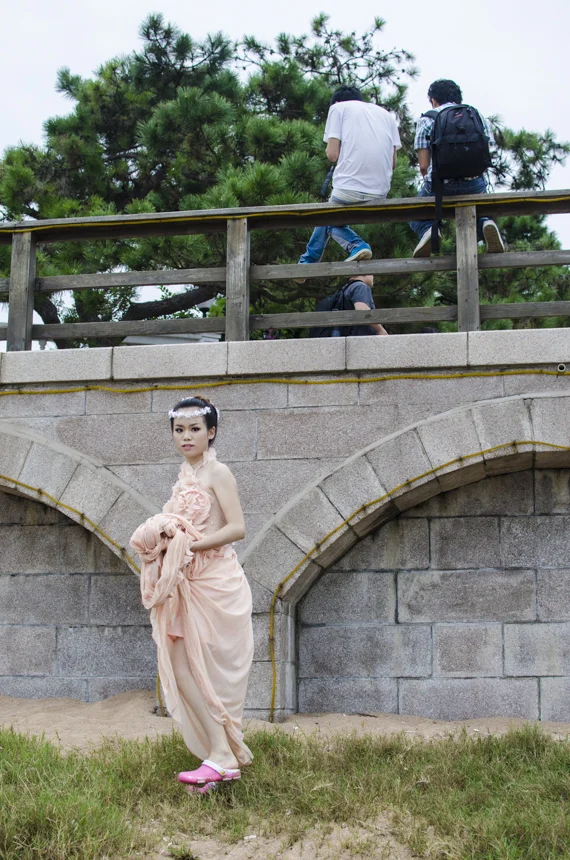 A woman walks in Crocs under her long-tail gown provided by the photo studio. 
