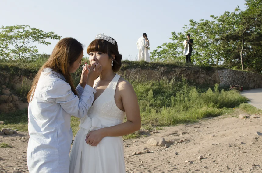 A bride-to-be is being touched up by her wedding photo studio's makeup artist. Having wedding photos taken before the magic day actually happens, has become a ritual fashioned by Chinese couples today whose parents might not have had the money for a picture when they got married 30 years ago. My hometown, Qingdao, on the east coast of China, is one city that happens to lead in the business of preserving happiness with photographs, because of the natural photo sets the coastline provides. 