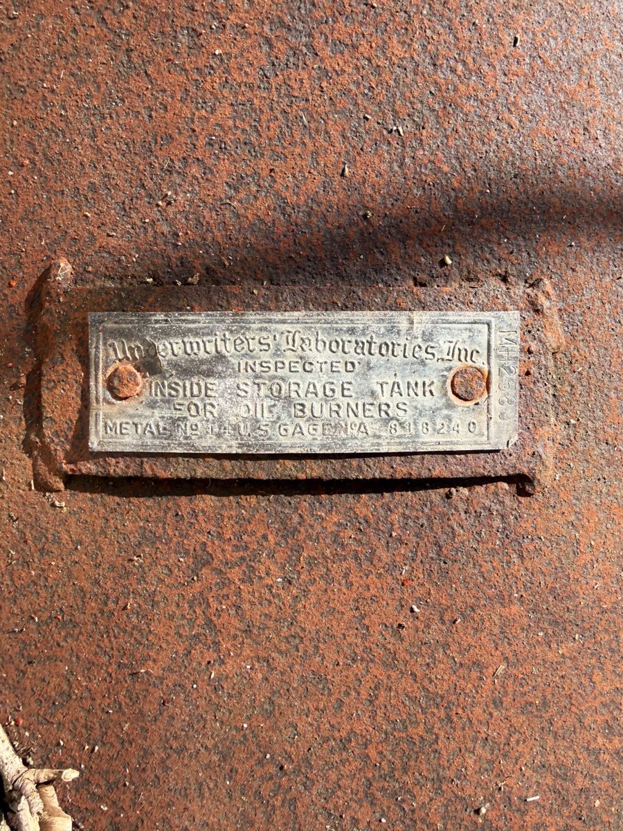 a beautiful metal label on a rusty oil tank
