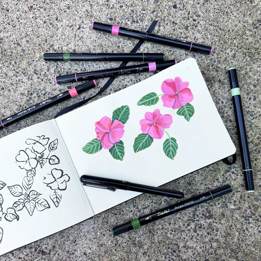 a sketchbook with brush pen sketches on one side and paint marker sketches on the other