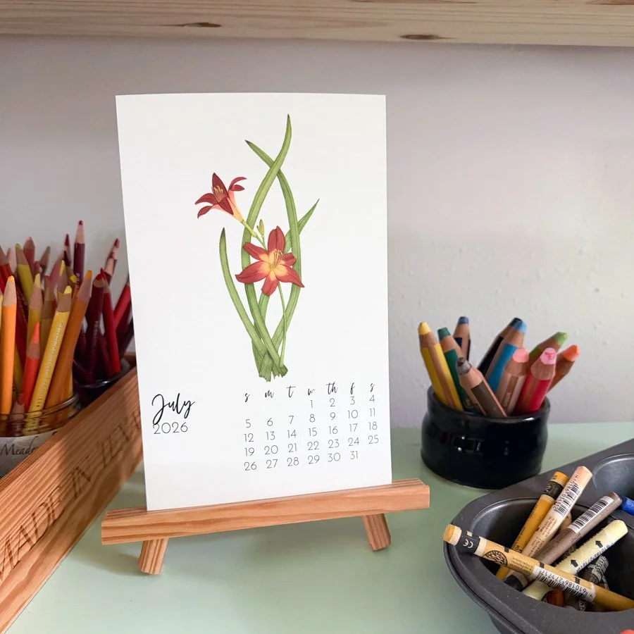 Anne Butera's 2026 July Calendar page features dark orange day lily flowers
