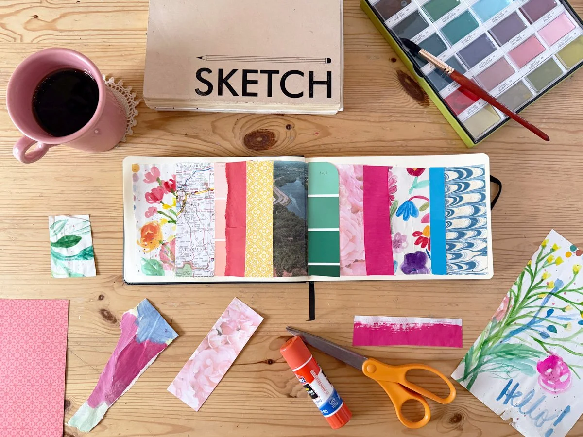 A beautifully messy art table with a patchwork collage in a sketchbook