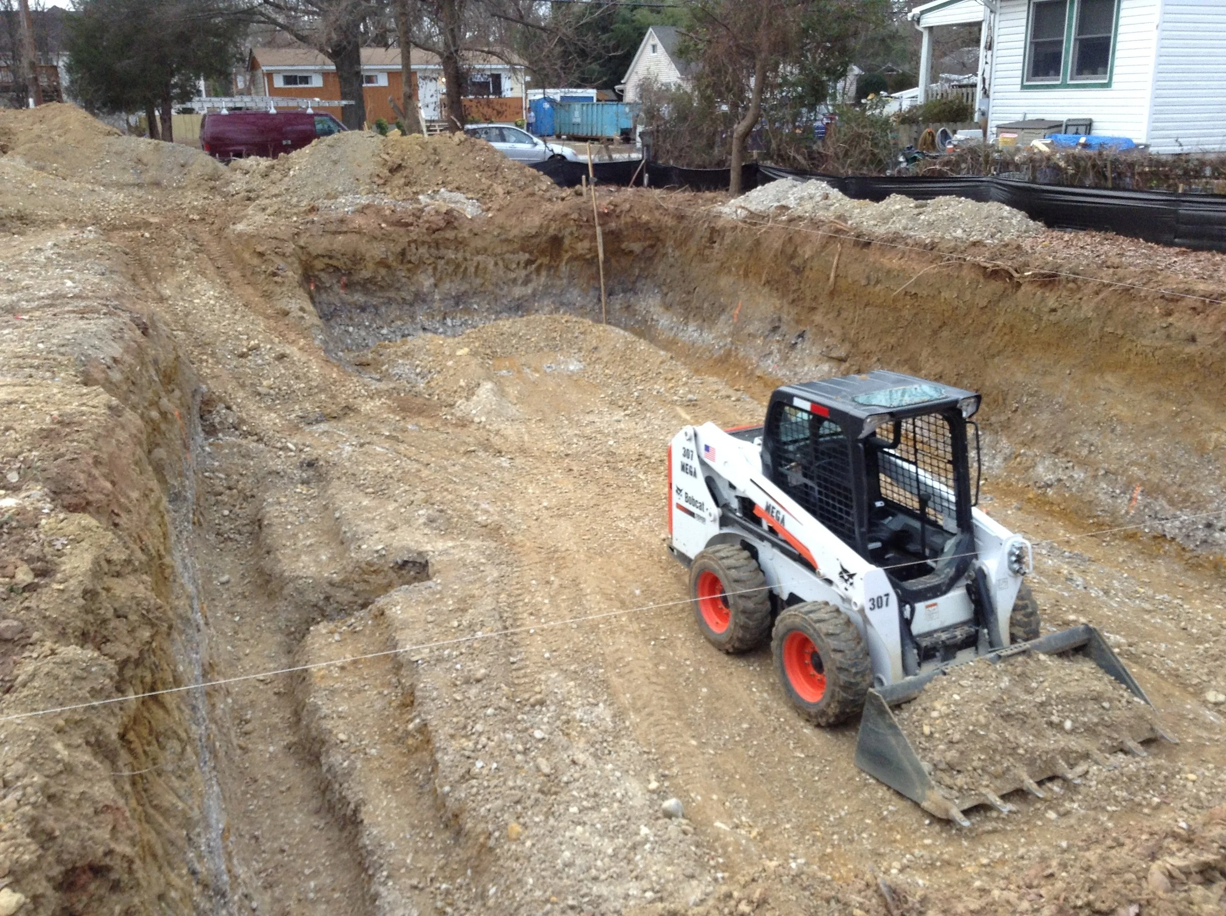 As can be seen there are three elevation heights that have been excavated. The deepest excavation is for the footings and for the location for the sump basin on the left hand side. The Bobcat is finishing removing the dirt from the slab elevation.